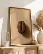 Cette affiche photo-réaliste artistique de grand format illustre un grain de café torréfaction moyenne capté comme une sculpture naturelle. Sa surface présente une patine craquelée et une matière riche, révélées par une lumière rasante sur un fond beige feutré L’image évoque la chaleur, le parfum latent, et ce moment précis où le café devient arôme.

Cette affiche minimaliste et organique rend hommage à la transformation du grain, dans une atmosphère silencieuse et tactile. Elle s’intègre parfaitement à un 