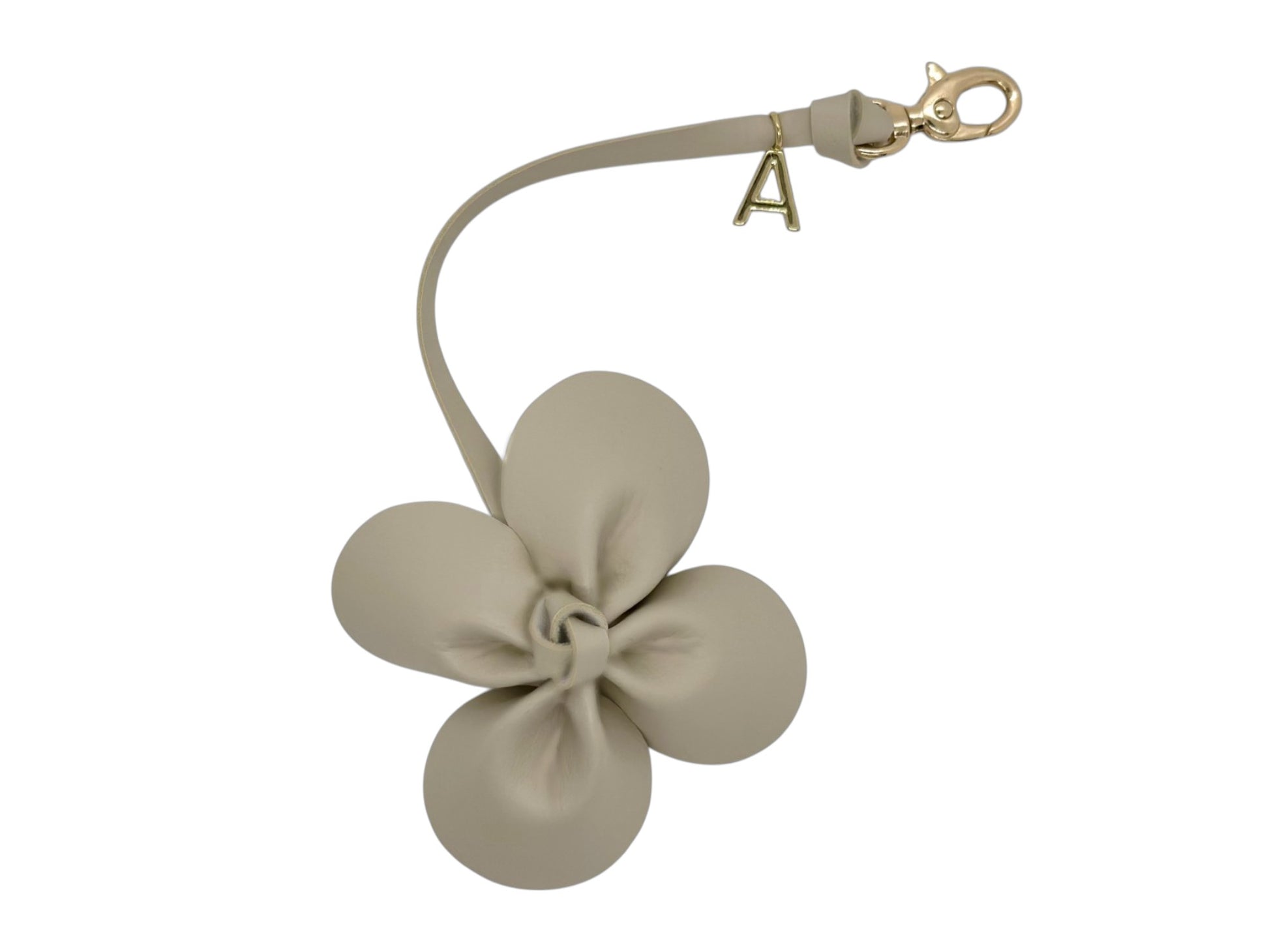 Breloque Fleur en simili cuir vegan de couleur sable fait à la main. Avec petit fermoir à pince doré et logo Absolument doré