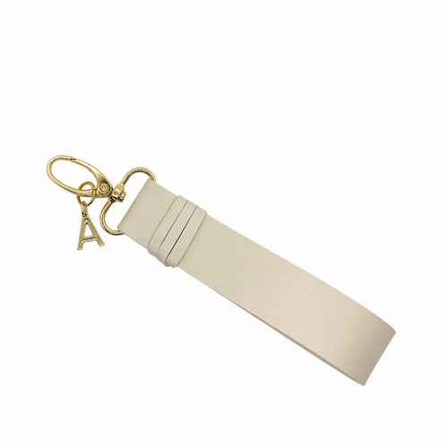 Porte-clés en simili cuir Vegan de couleur sable  fait à la main au Québec incluant un fermoir à pince doré ainsi que le logo signature Absolument doré