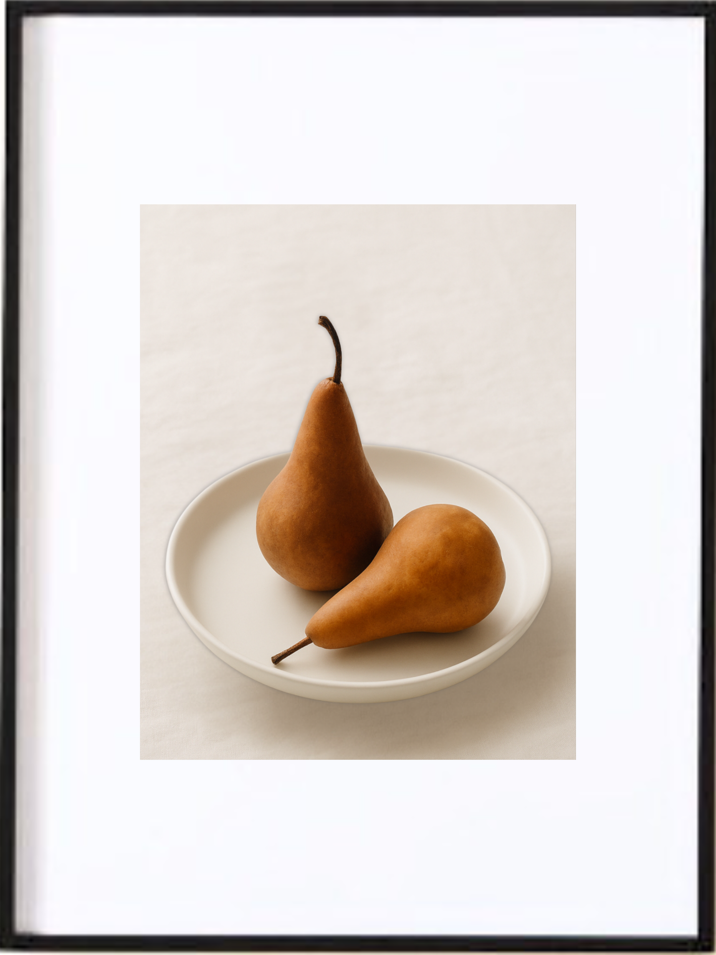 Cette affiche imprimée illustre deux poires complices déposées dans une assiette minimaliste. Les teintes chaleureuses et la lumière douce créant une atmosphère accueillante, invitant chacun à s’asseoir et à savourer un instant simple et gourmand.