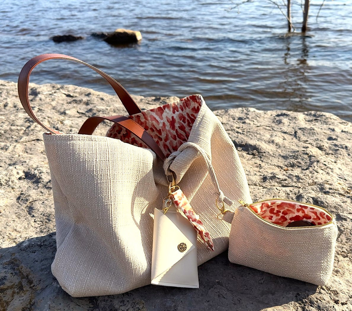 SAc en tissus réversible et fait à la main au QUébec par l'Atelier Absolument. UnUn coté du sac est en tissus canevas beige et l'autre coté en coton rouge et crème avec un motif léopard. Les ganses sont en simili cuir vegan Tan. Pochette en tissus assorti avec fermeture éclair métallique de couleur or. Porte-cartes en simili cuir vegan de couleur crème avec bouton horoscope antique brass et fermoir à pince couleur dorée. POrte clés en tissu léopard rouge et crème. Logo signature Absolument couleur doré. 