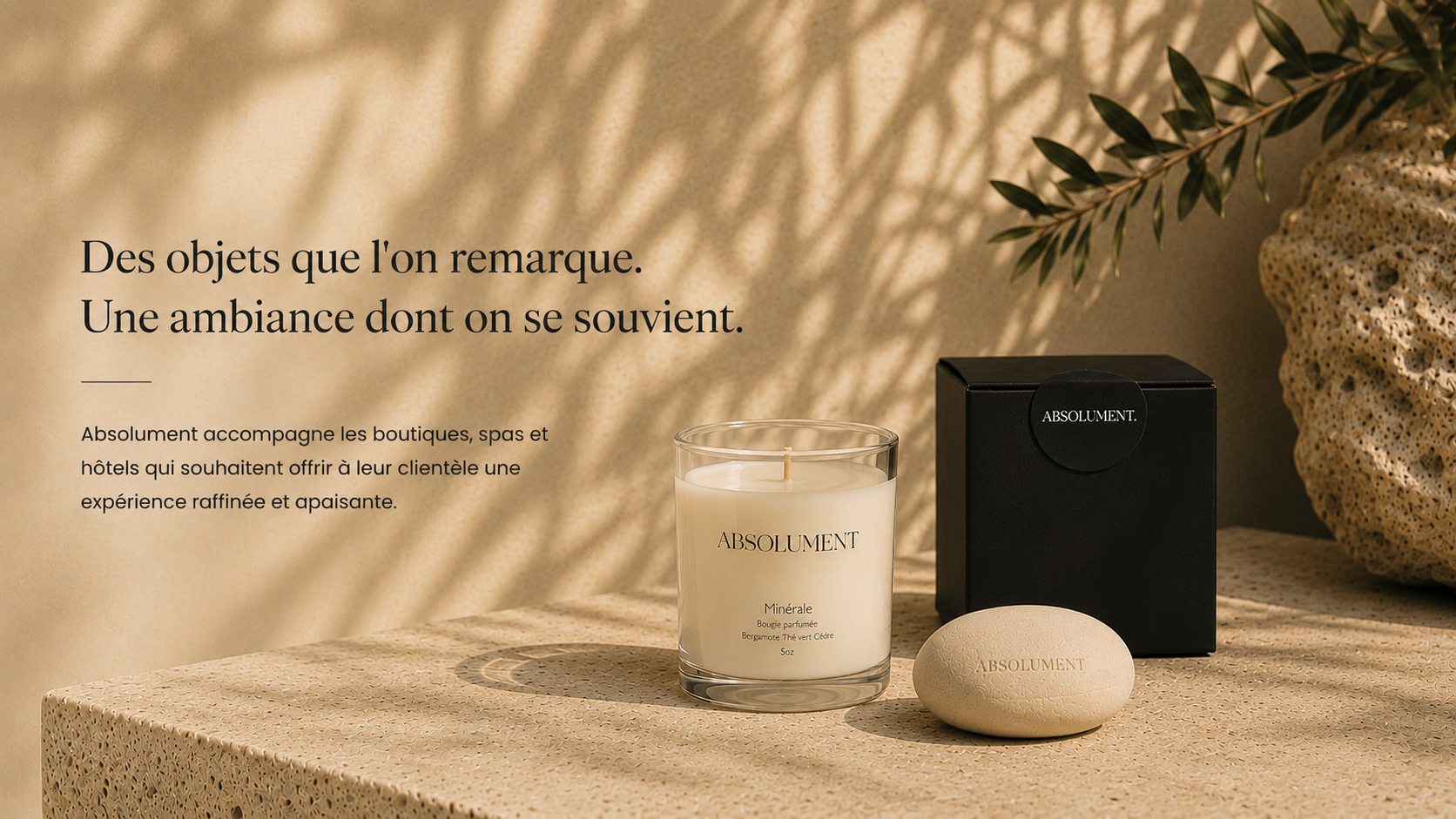 Produits Absolument pour la revente en boutique, incluant une bougie parfumée artisanale et un galet fabriqués au Québec.